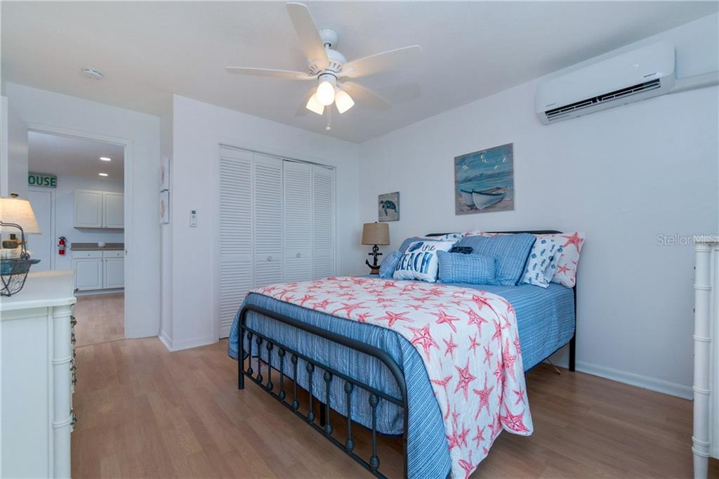 5041 North Beach Road, Unit 3B Englewood, FL 34223 - Photo 20 of 55 a bedroom with a bed and a chandelier