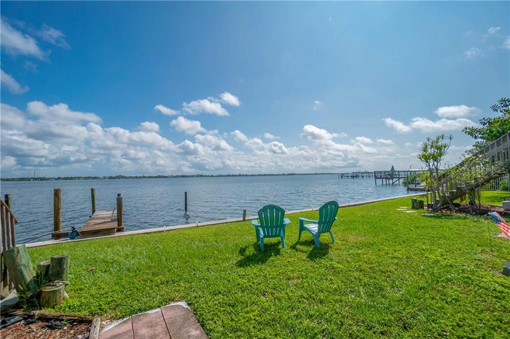 5041 North Beach Road, Unit 3B Englewood, FL 34223 - Photo 30 of 55 a view of a garden with lawn chairs and a large tree