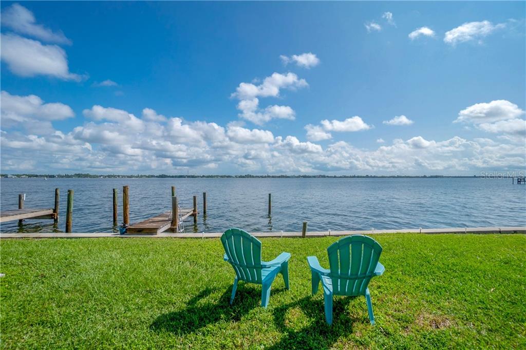 5041 North Beach Road, Unit 3B Englewood, FL 34223 - Photo 39 of 55 a view of a lake with table and chairs