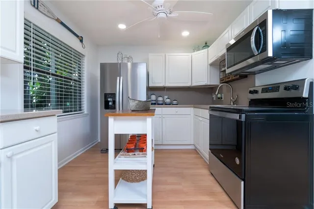 a kitchen with stainless steel appliances granite countertop a refrigerator a stove top oven a sink and dishwasher