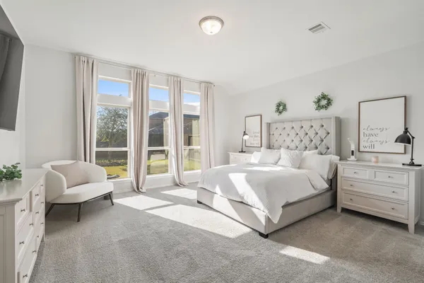a spacious bedroom with a bed and a couch