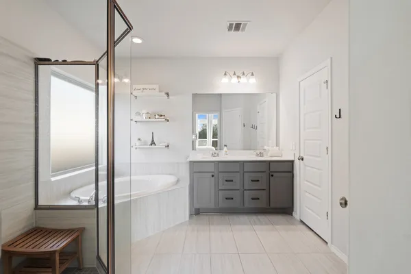 a spacious bathroom with a tub sink shower and mirror