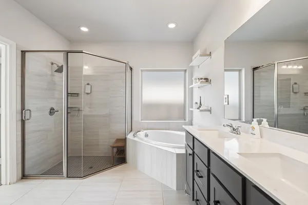 a bathroom with a double vanity sink mirror and shower