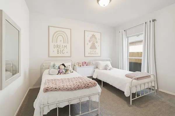a bedroom with two beds and a window