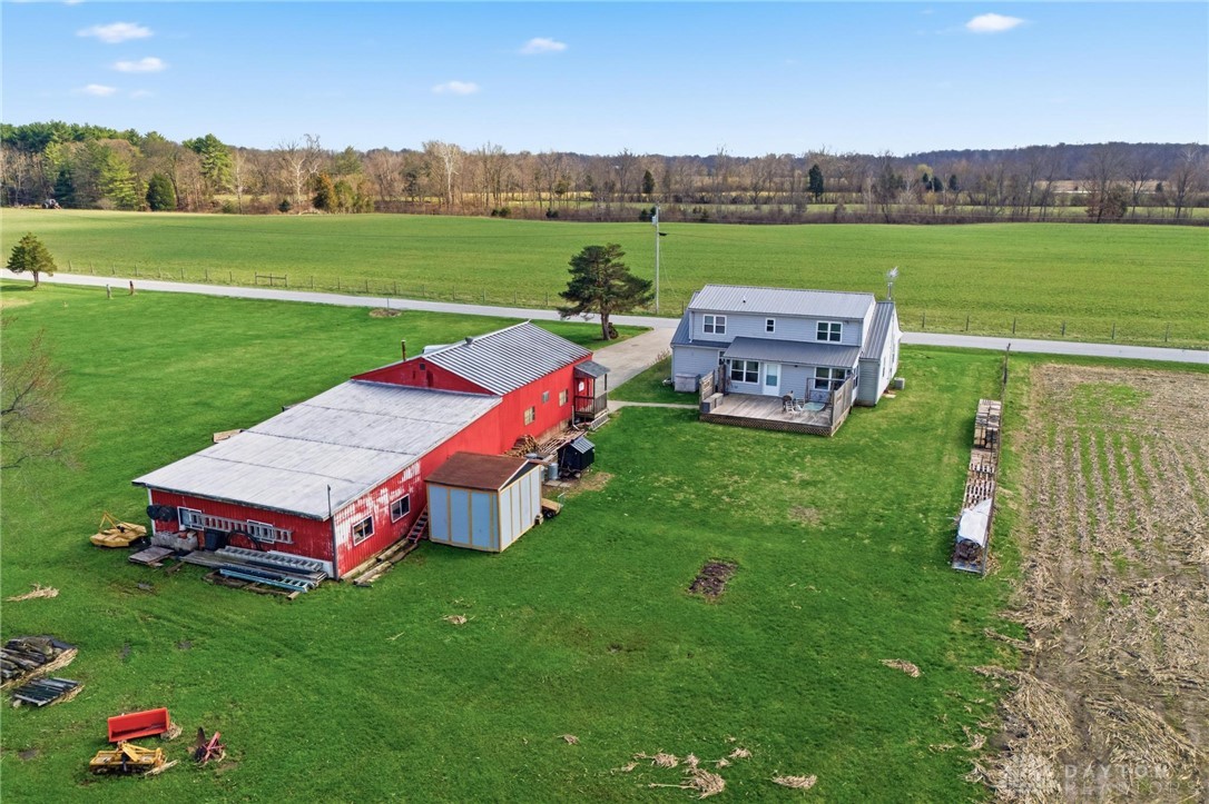 11379 Friend Road Germantown, OH 45327 - Photo 38 of 44 This expansive rural property features a residence with a deck, a large red barn, and vast open fields.