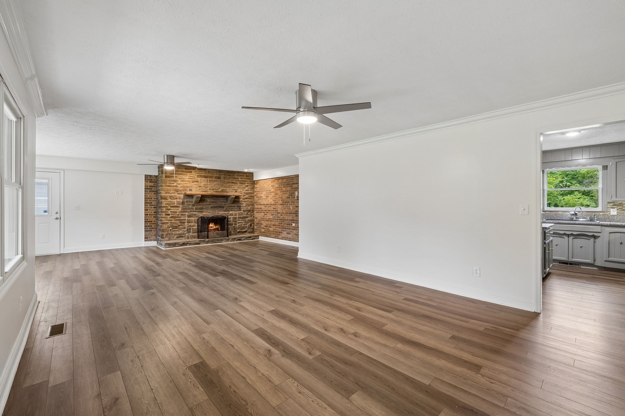 1397 East Blue Creek Road Waverly, TN 37185 - Photo 11 of 93 an empty room with wooden floor a ceiling fan and windows