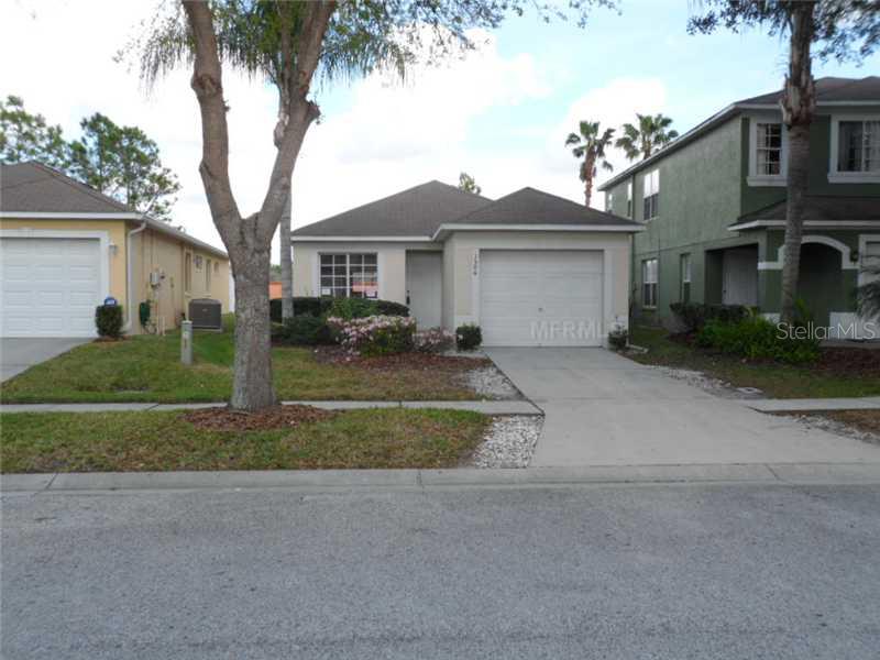 1504 Rincon Drive Wesley Chapel, FL 33544 - Photo 1 of 1 a view of a white house next to a yard with palm trees