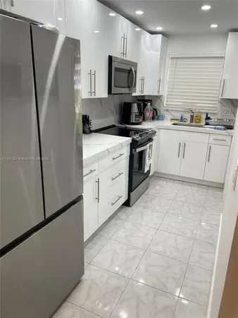 a kitchen with stainless steel appliances a refrigerator sink and microwave