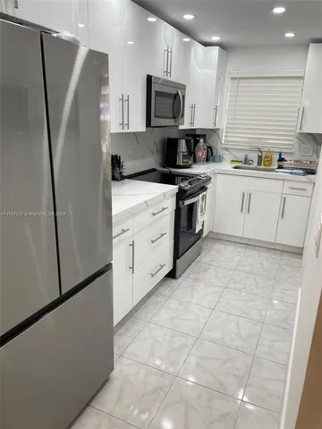 a kitchen with stainless steel appliances a refrigerator sink and microwave