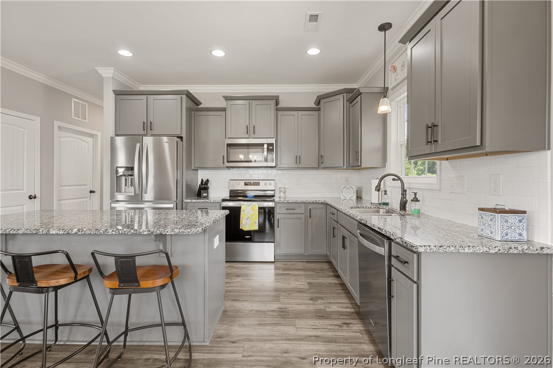 137 Minter School Road Sanford, NC 27332 - Photo 12 of 50 a kitchen with stainless steel appliances granite countertop a stove a sink and a refrigerator