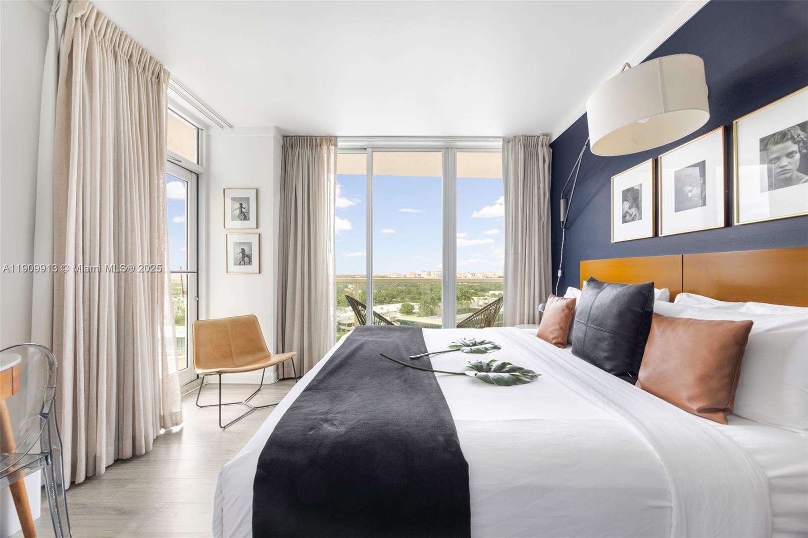 2889 McFarlane Road, Unit 1512 Coconut Grove, FL 33133 - Photo 12 of 25 a bedroom with a bed and a lamp next to a large window