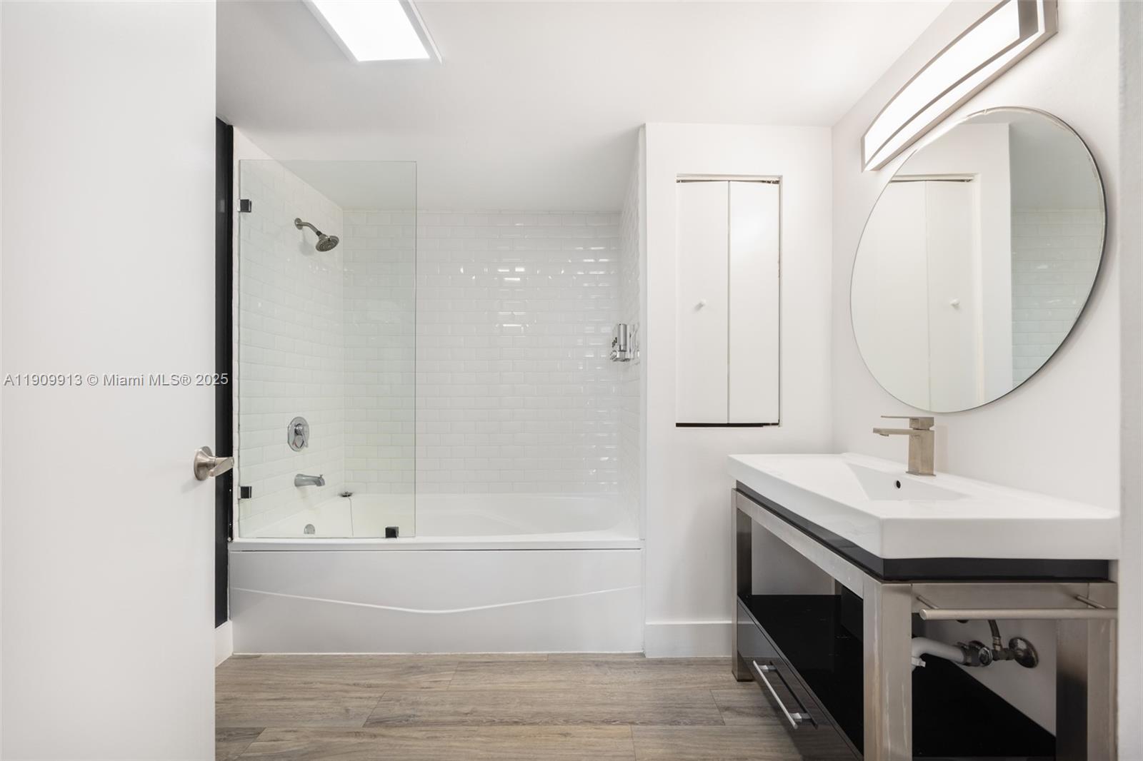 2889 McFarlane Road, Unit 1512 Coconut Grove, FL 33133 - Photo 14 of 25 a bathroom with a sink a mirror and a bathtub