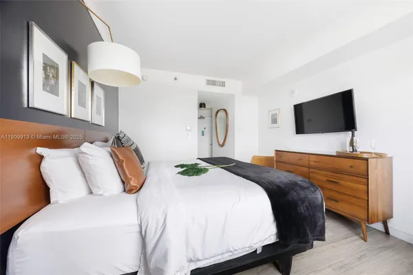 a bedroom with a bed and a flat screen tv