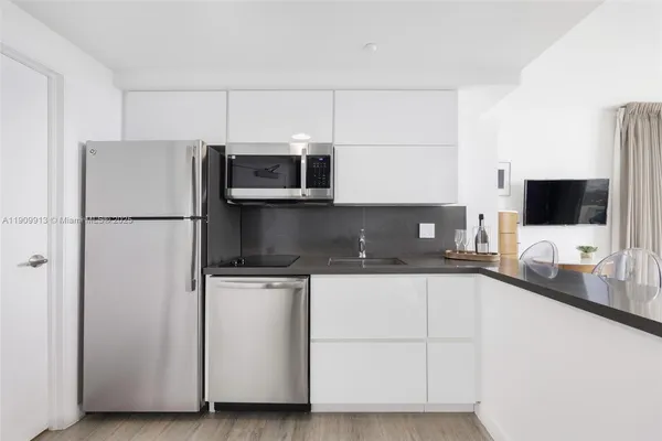 a kitchen with stainless steel appliances a sink and a refrigerator