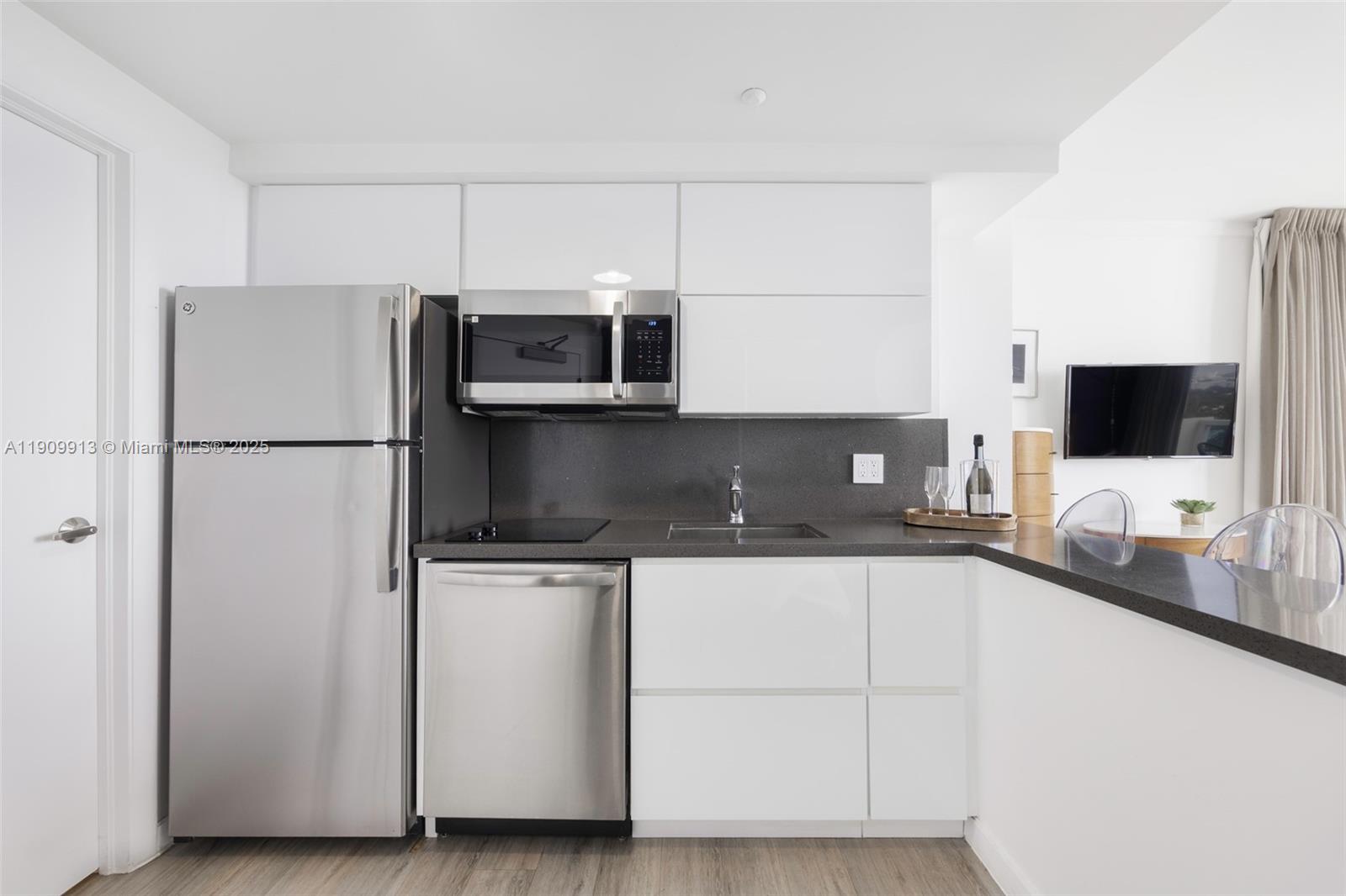 2889 McFarlane Road, Unit 1512 Coconut Grove, FL 33133 - Photo 8 of 25 a kitchen with stainless steel appliances a sink and a refrigerator