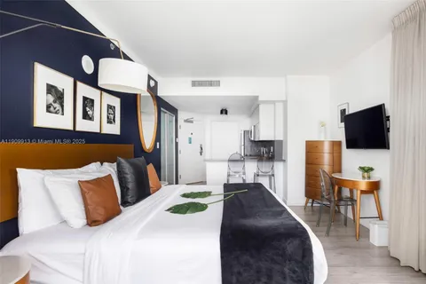 a bedroom with a bed and a lamp next to a large window