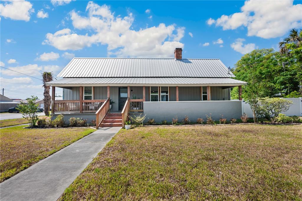 a view of a house with backyard and sitting area