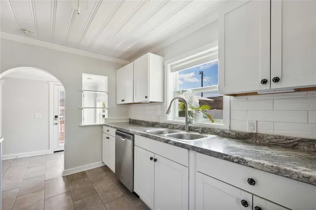 a kitchen with granite countertop a sink a stove and refrigerator