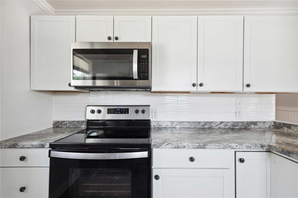 113 West Noble Avenue Bushnell, FL 33513 - Photo 14 of 56 a kitchen with granite countertop white cabinets and appliances