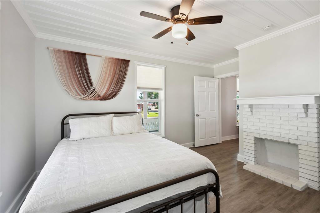 113 West Noble Avenue Bushnell, FL 33513 - Photo 15 of 56 a bedroom with a bed and a fireplace