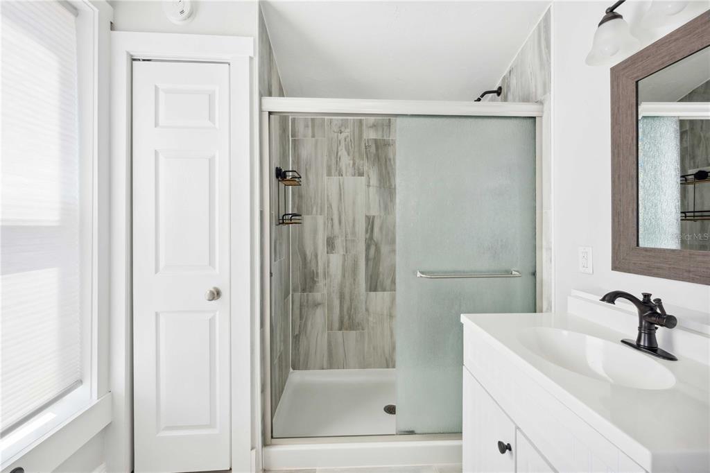 113 West Noble Avenue Bushnell, FL 33513 - Photo 25 of 56 a bathroom with a shower a mirror and a sink