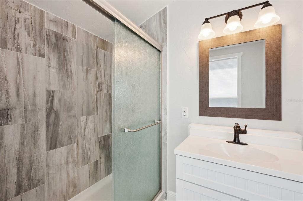 113 West Noble Avenue Bushnell, FL 33513 - Photo 26 of 56 a bathroom with a sink a mirror and a shower