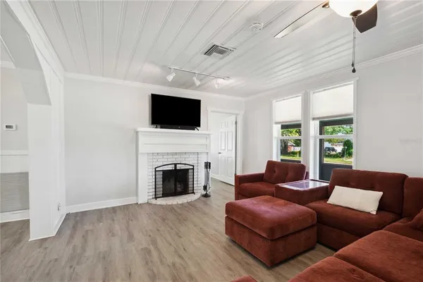 a living room with furniture a fireplace and a flat screen tv
