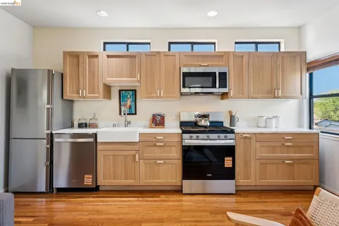 a kitchen with stainless steel appliances a stove microwave and refrigerator
