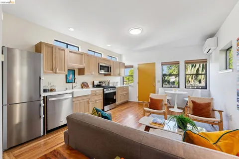 a kitchen with a refrigerator a stove top oven a sink dishwasher and white cabinets with wooden floor