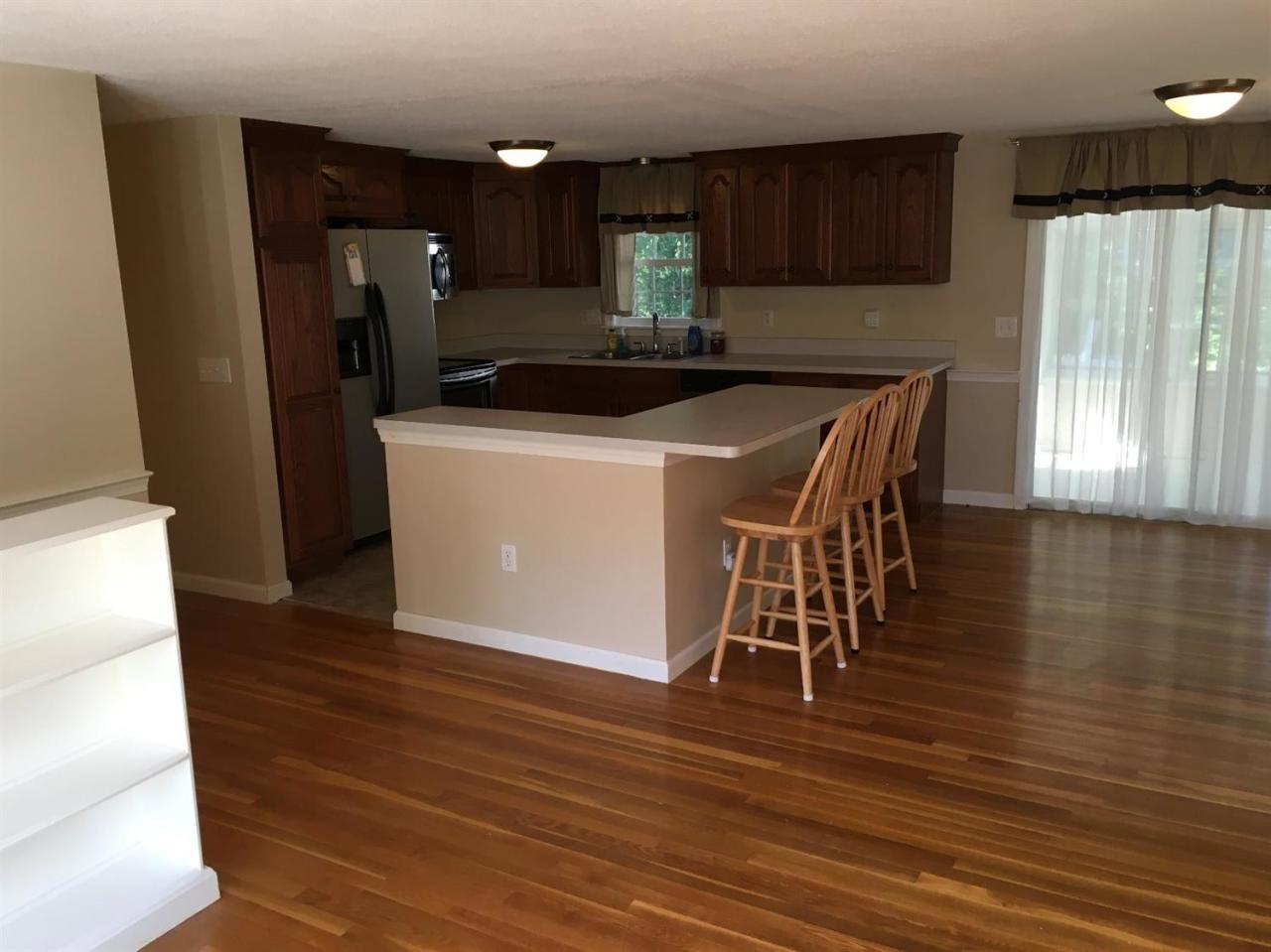 54 Great Marsh Road Centerville, MA 02632 - Photo 6 of 25 a kitchen with a table chairs refrigerator and cabinets