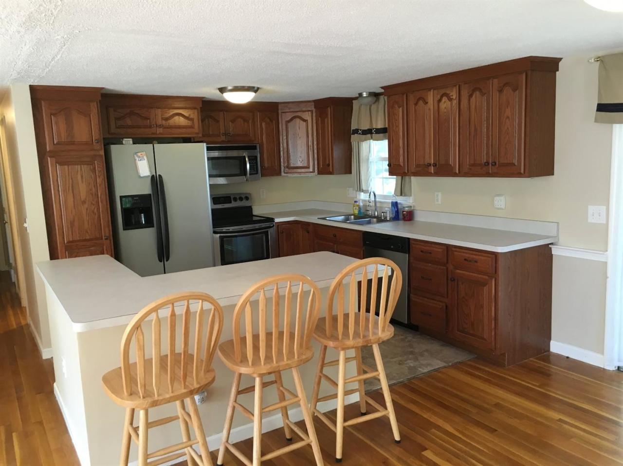 54 Great Marsh Road Centerville, MA 02632 - Photo 8 of 25 a kitchen with stainless steel appliances kitchen island granite countertop a refrigerator a stove top oven a sink and dishwasher