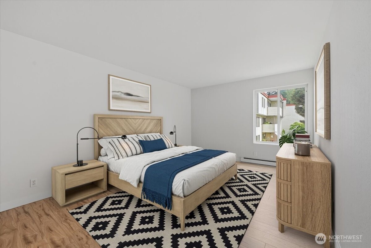 8516 196th Street Southwest, Unit 204 Edmonds, WA 98026 - Photo 14 of 16 a bedroom with a bed and wooden floor
