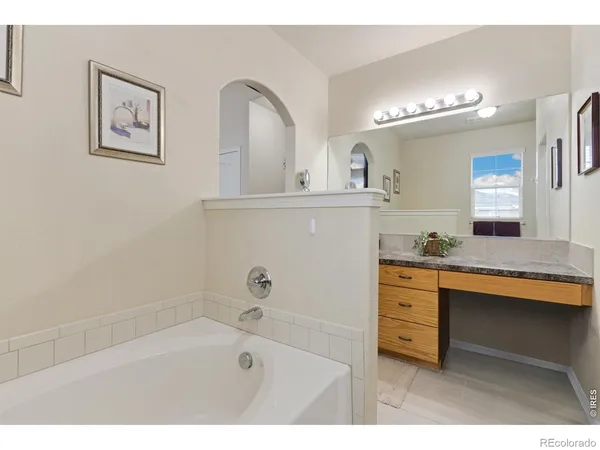 a bathroom with a sink a large mirror and a bathtub