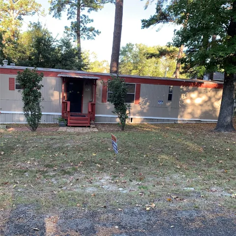 a view of a house with backyard and trees