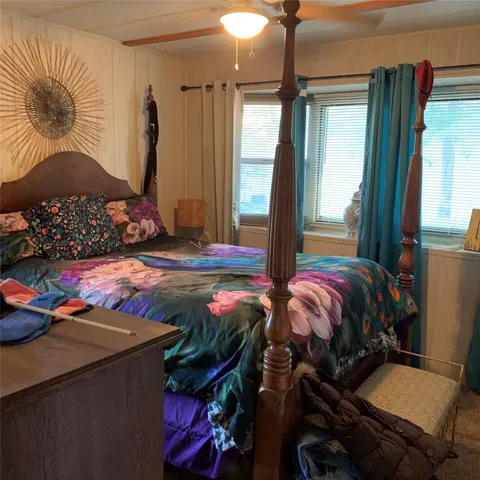 a bedroom with a bed and large windows