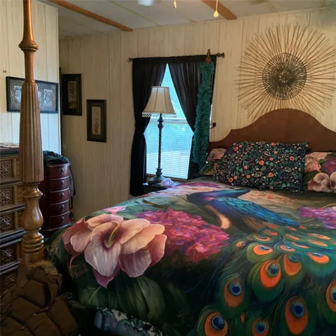 a bedroom with a bed and a painting on the wall
