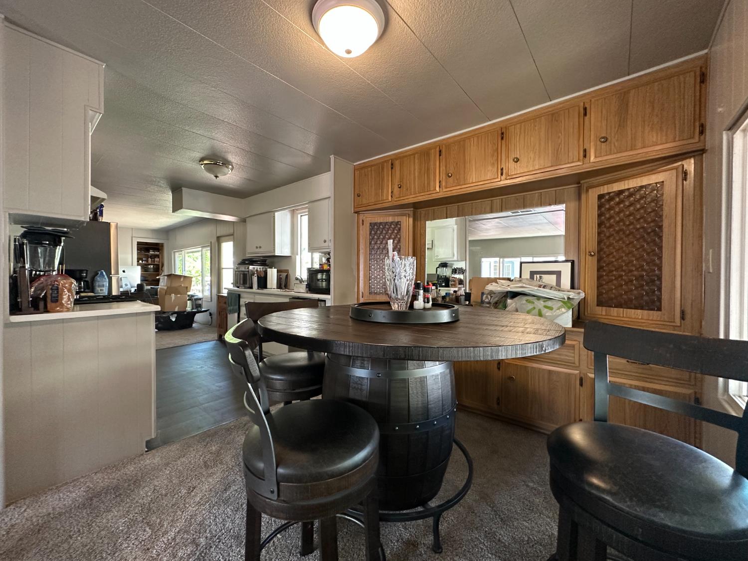 14610 Mono Way, Unit 65 Sonora, CA 95370 - Photo 15 of 24 a kitchen with sink a refrigerator and chairs