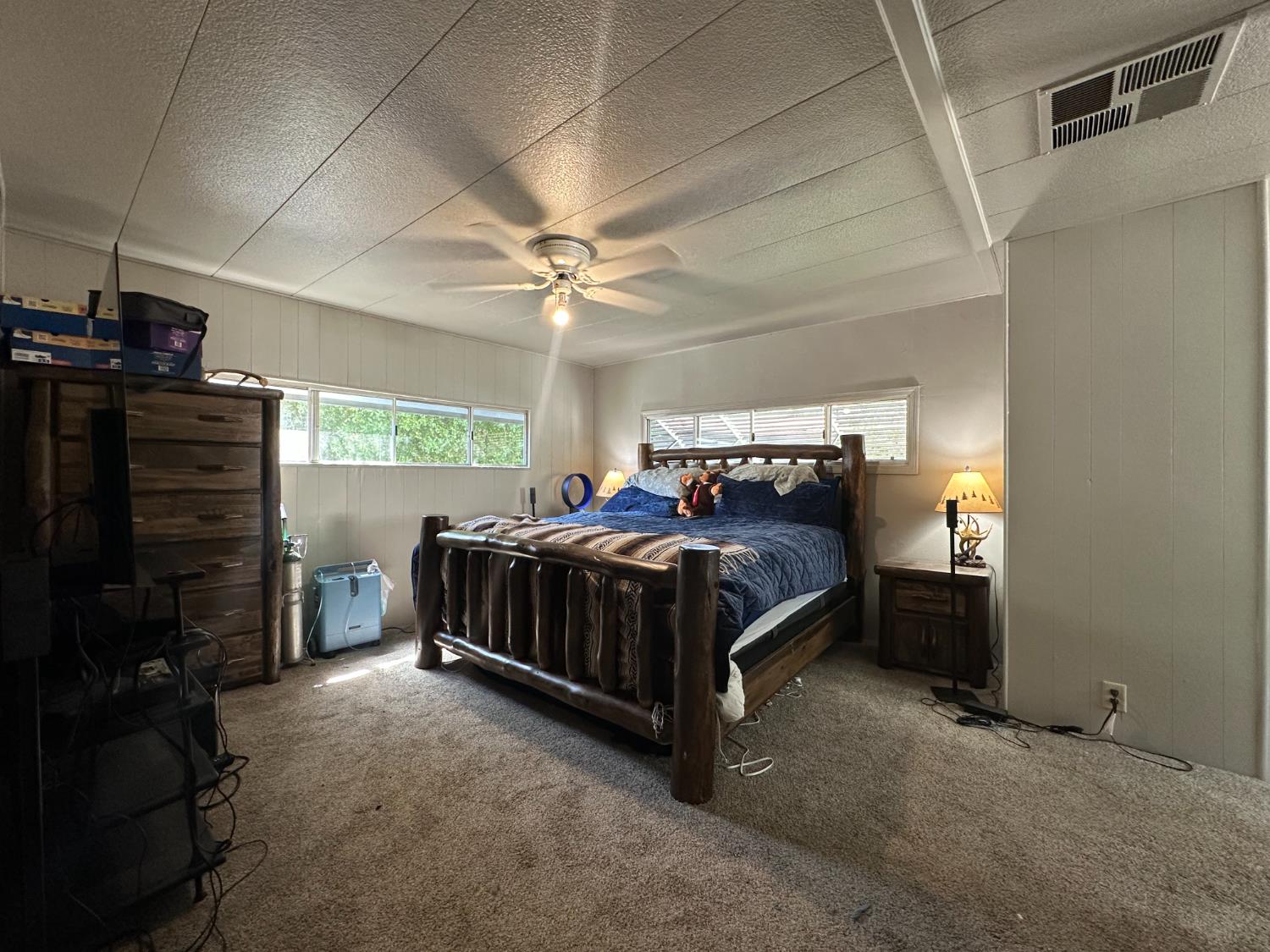 14610 Mono Way, Unit 65 Sonora, CA 95370 - Photo 4 of 24 a bedroom with a bed and a ceiling fan