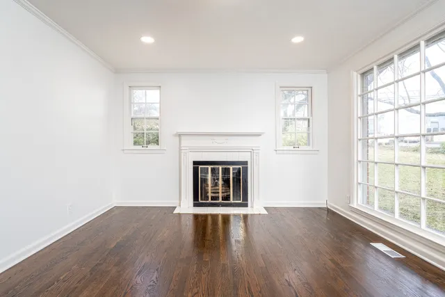 wooden floor fireplace and windows in an empty room
