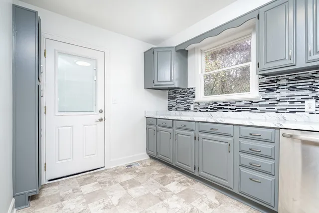 a kitchen with granite countertop cabinets sink and window