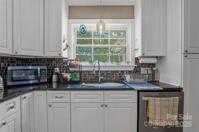 a kitchen with sink a window and cabinets