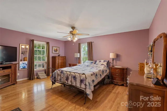 a bedroom with a bed and a flat tv screen on dresser