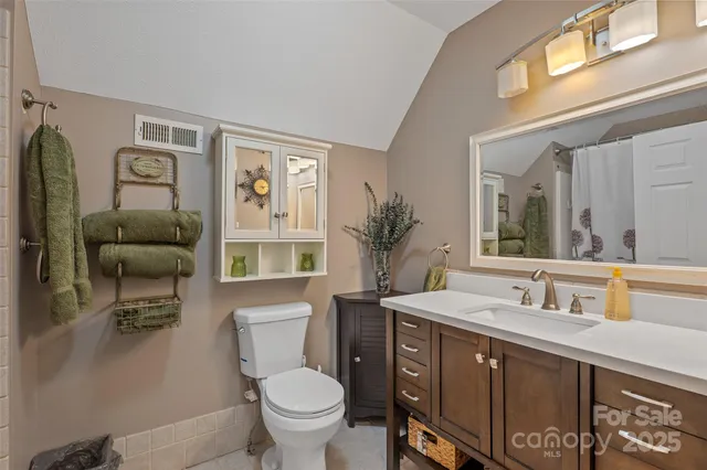 a bathroom with a toilet a sink and a large mirror