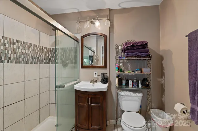 a bathroom with a sink a toilet and shower