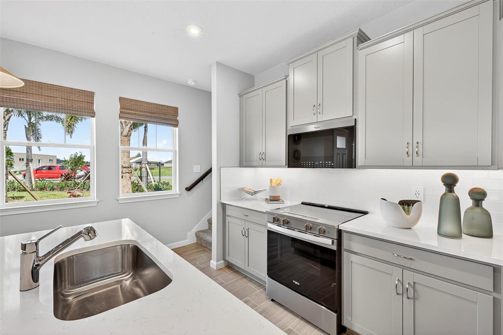8830 Ginko Run Parrish, FL 34219 - Photo 8 of 29 a kitchen with granite countertop a sink stainless steel appliances and cabinets