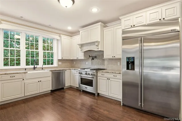a kitchen with white cabinets and appliances