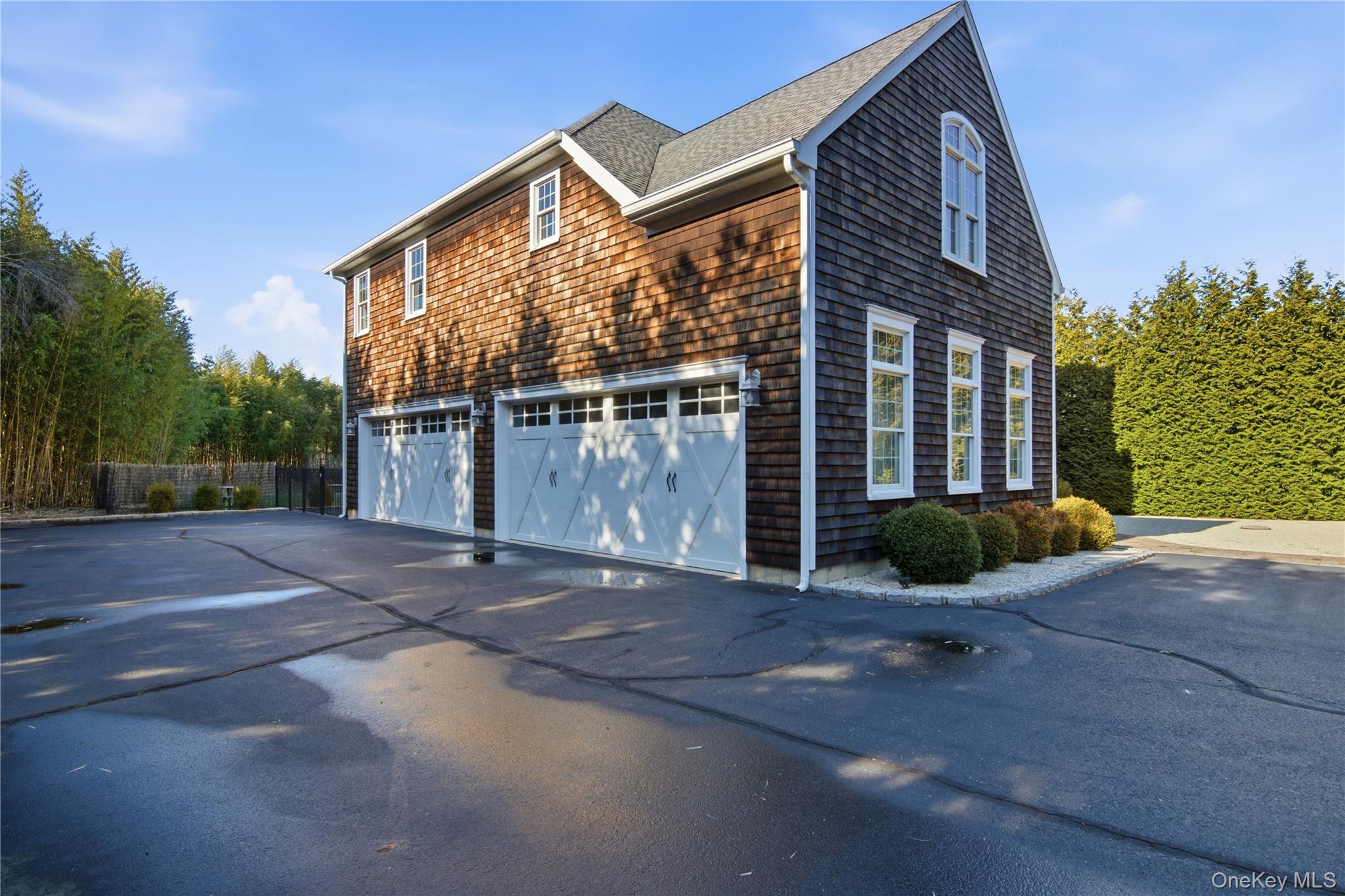69 Old Depot Road Quogue, NY 11959 - Photo 2 of 40 View of home's exterior with an attached garage, asphalt driveway, and roof with shingles