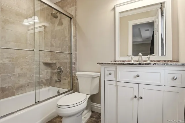a bathroom with a granite countertop sink toilet mirror and shower