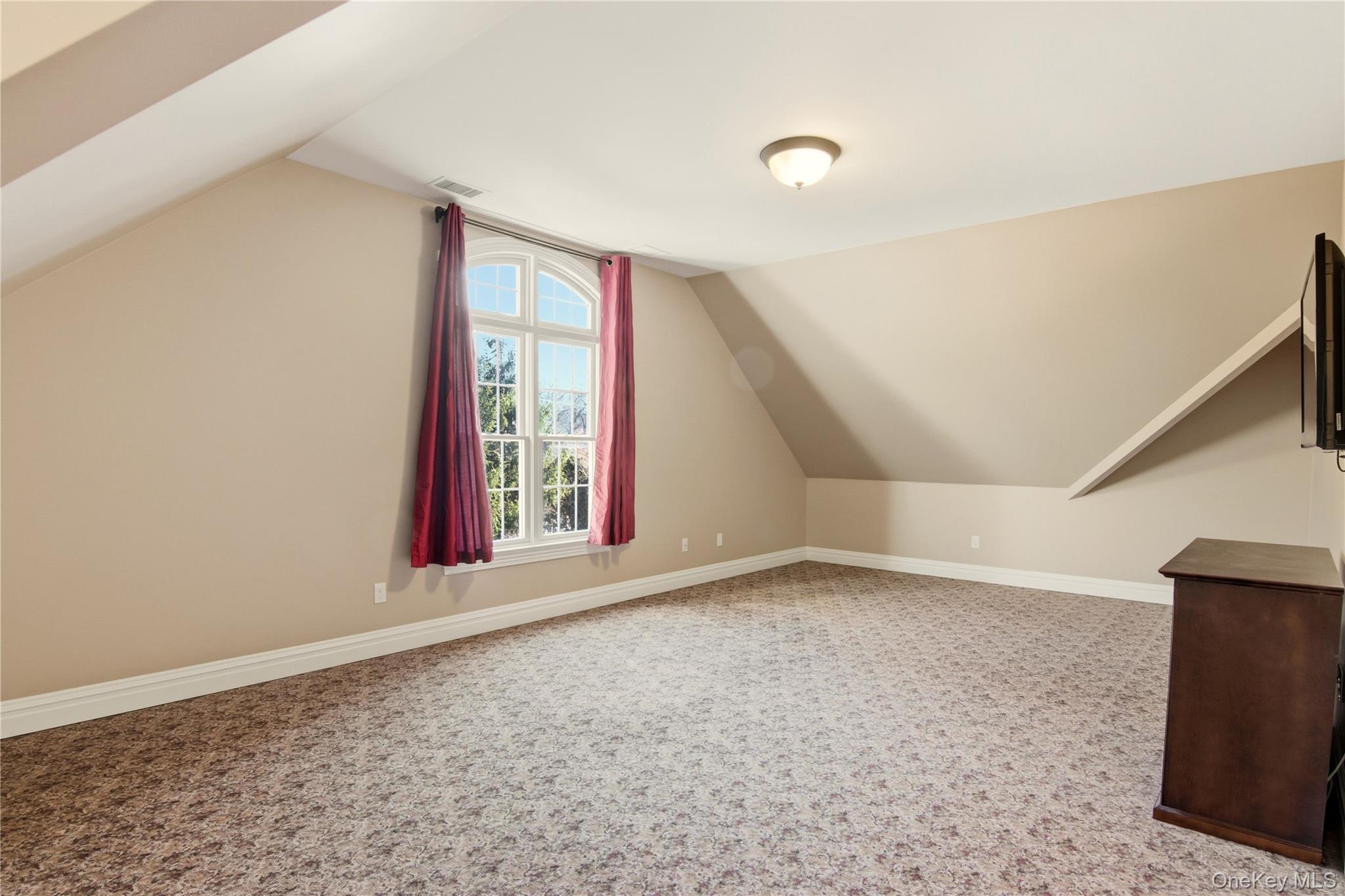 69 Old Depot Road Quogue, NY 11959 - Photo 27 of 40 Bonus room with lofted ceiling and carpet