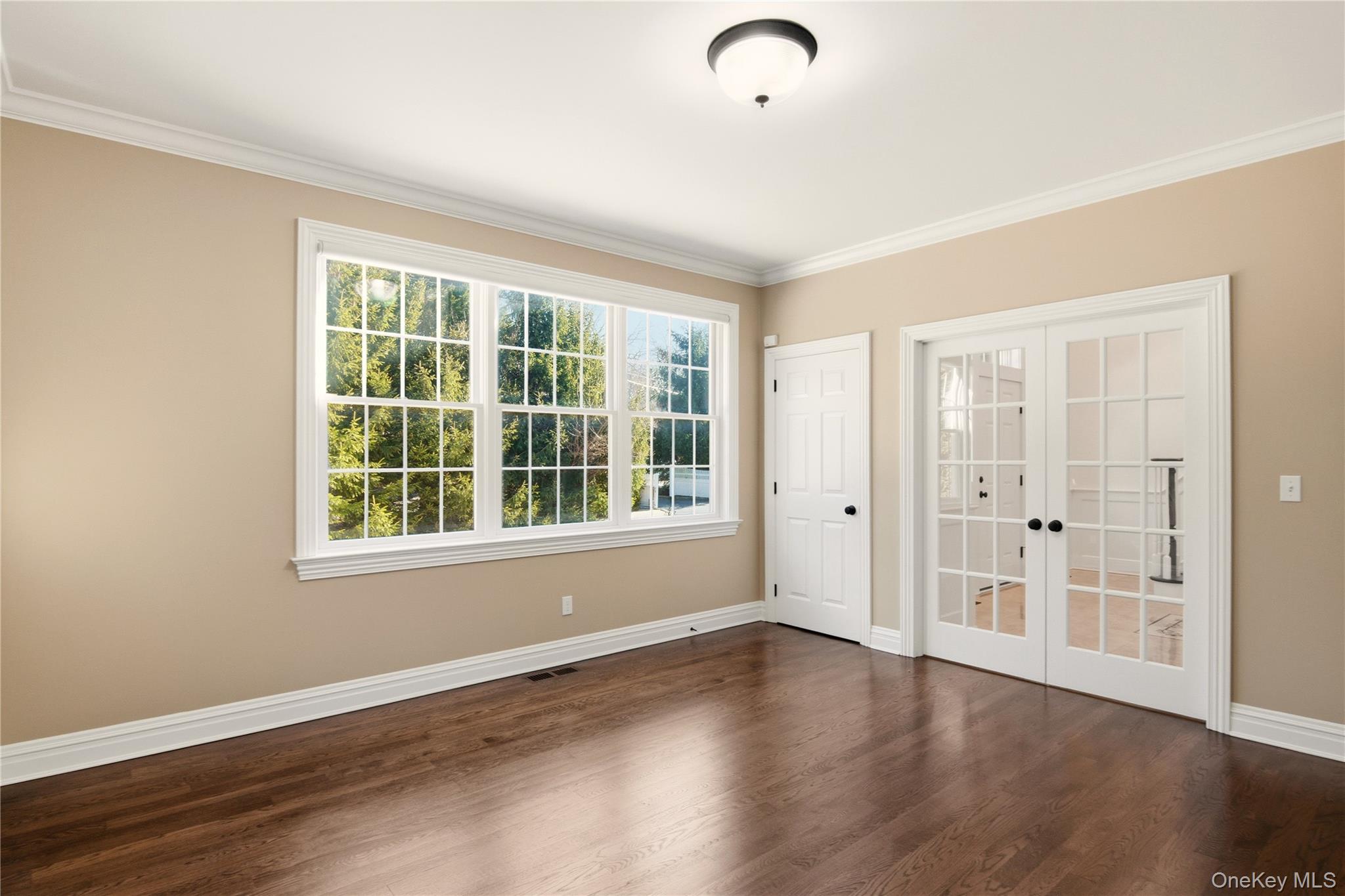69 Old Depot Road Quogue, NY 11959 - Photo 8 of 40 Unfurnished room with french doors, dark wood finished floors, and ornamental molding